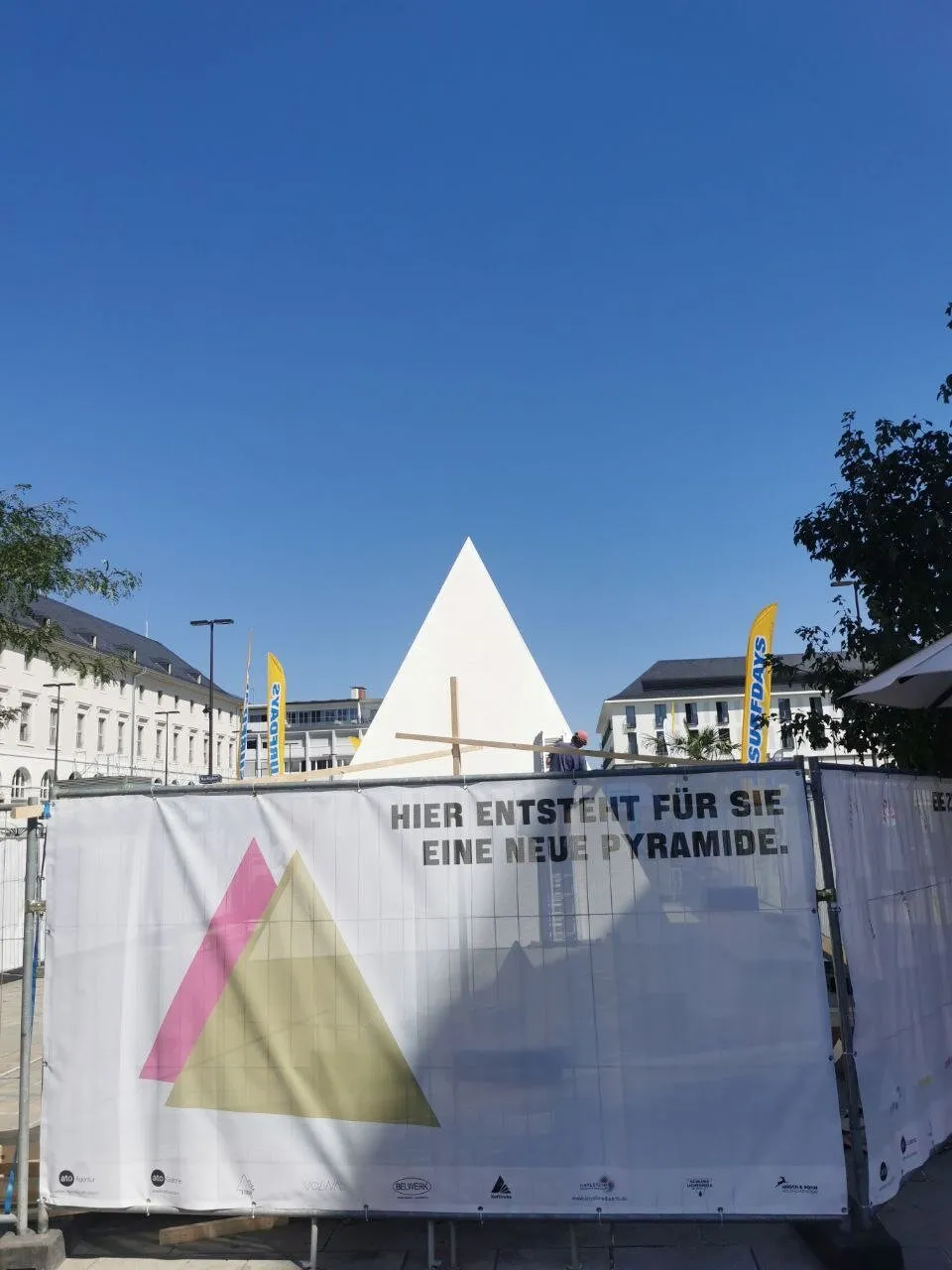 Aufbau · die verkleidete Pyramide hinter dem Bauzaun